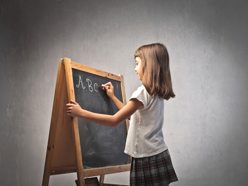 girl writing on blackboard